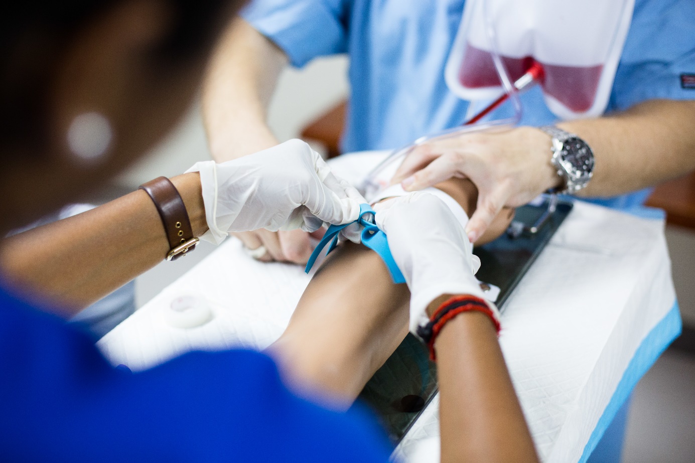 A nurse putting a needle on a patient's arm

Description automatically generated
