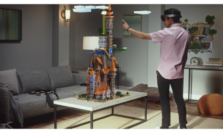 A person wearing virtual reality headset pointing at a model of a castle

Description automatically generated
